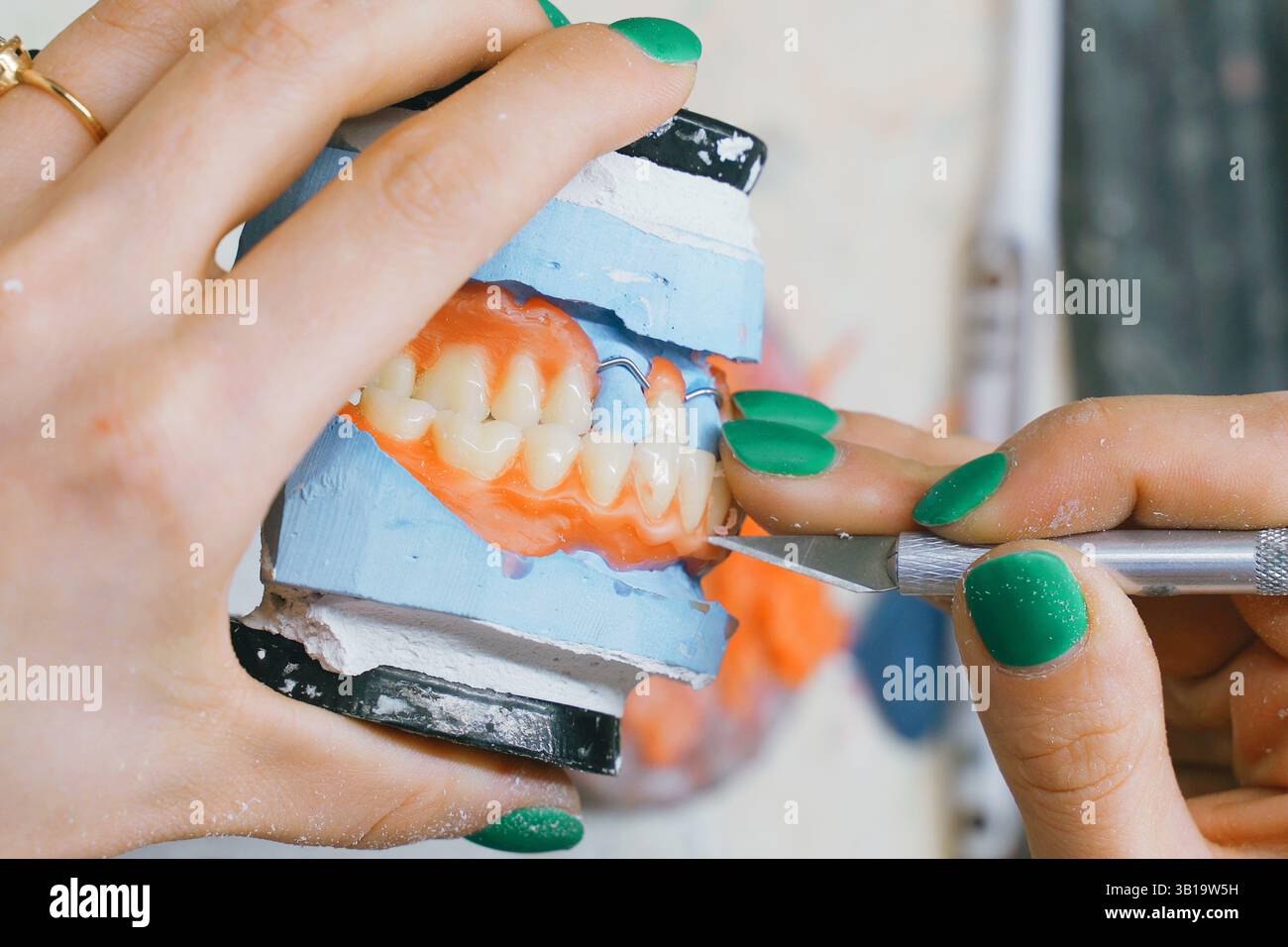 In un'officina specializzata, un odontotecnico si concentra sulla creazione di una dentatura precisa. Foto Stock