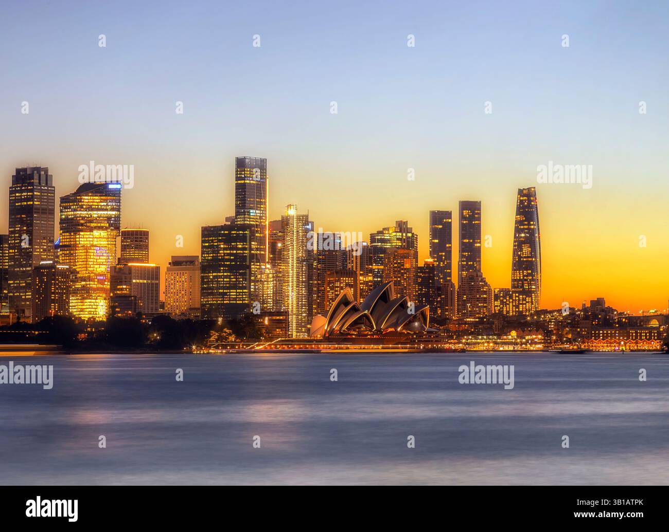 Colori luminosi del tramonto nel cielo sopra l'alto edificio della città di Sydney sullo skyline della costa del porto in Australia. Foto Stock