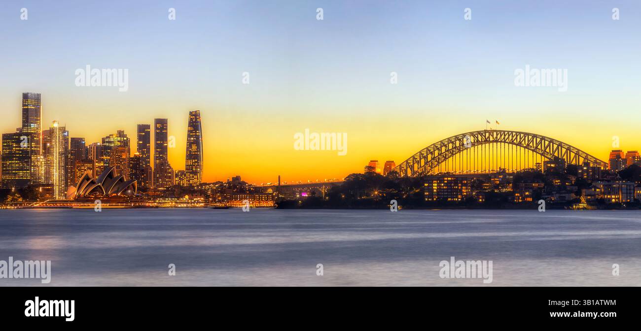 Colori luminosi del tramonto nel cielo sopra i punti di riferimento architettonici della città di Sydney, lo skyline della costa del porto in Australia. Foto Stock
