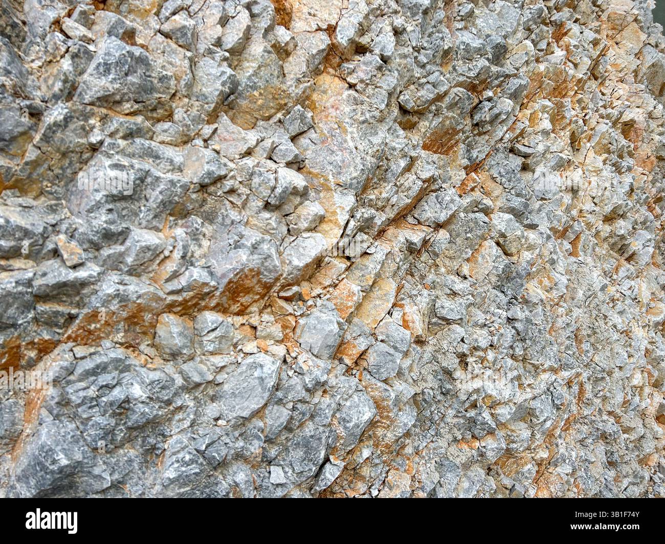 Schema ravvicinato di pietra resistente agli agenti atmosferici incastonata nella roccia, adatto come sfondo testurizzato. - Immagine stock catturata con smartphone