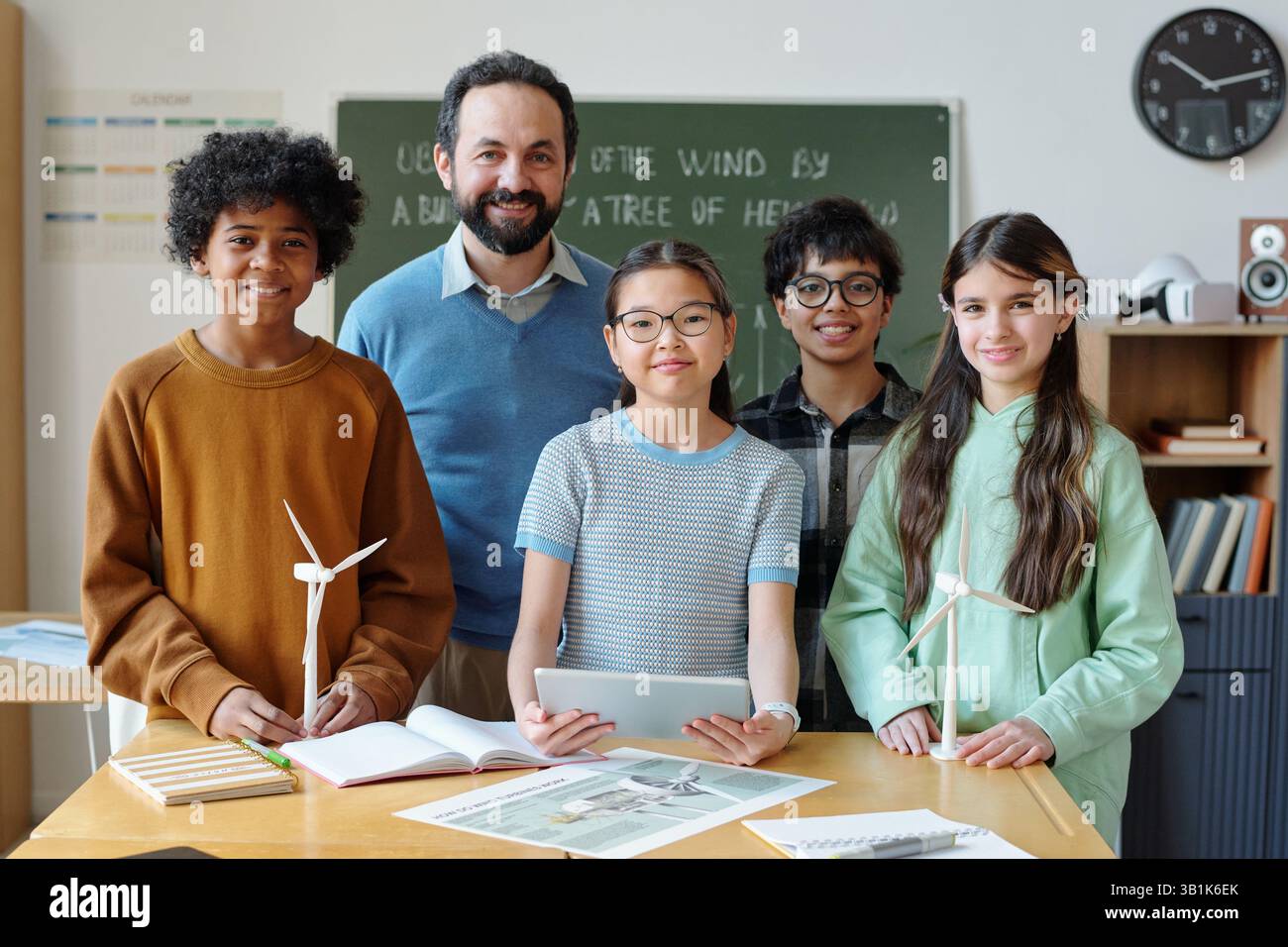 Gruppo di studenti e insegnanti che posano in aula Foto Stock