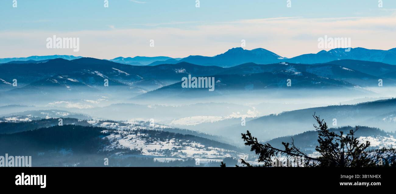Splendida vista sulla zona orientale di Mala Fatra, Nizke Tatry e sulle colline inferiori dalla collina di Barania Gora in inverno sulle montagne di Beskid Slaski in Polonia Foto Stock