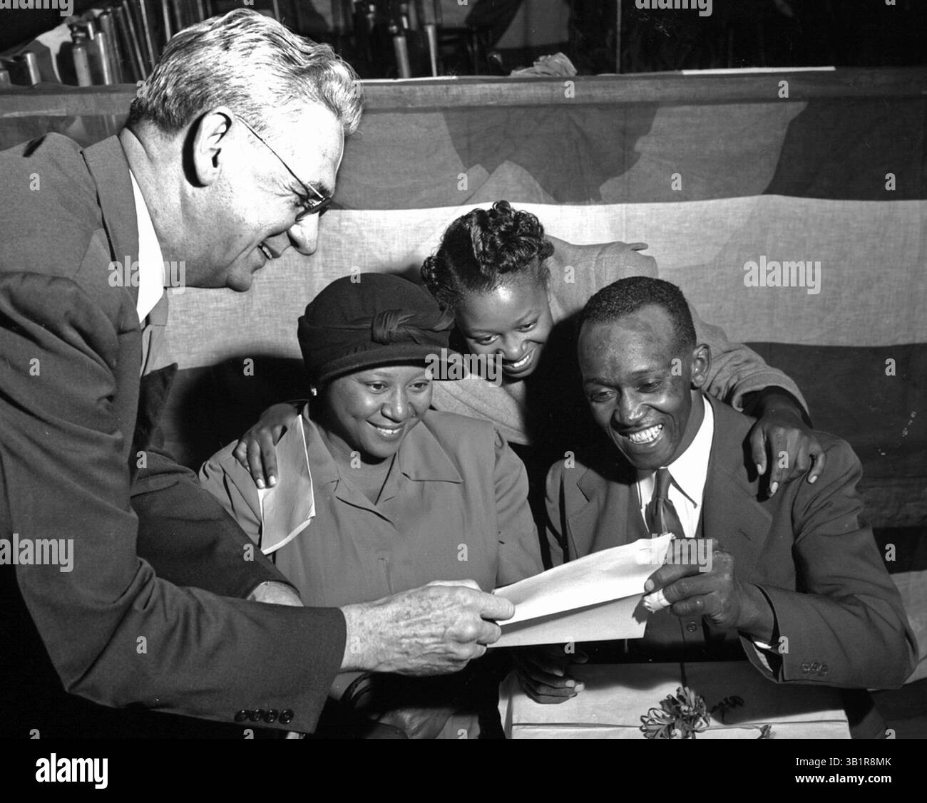 20 dicembre 1951 - Memphis, TN, Stati Uniti - FLOYD SHERROD (a sinistra) della camera di commercio di Memphis ha presentato il premio del 50 al Commercial Appeal's 1951 Live-at-Home Competition a ESSIE MAE BOONE, EUNELL BOONE e WILLIE B. BOONE di Madison County, Tenn., al 14° Live-at-Home Rally annuale alla BOOKER T. WASHINGTON High School il 20 dicembre 1951. Proprietari di una fattoria di 75 acri, i Boones sconfissero circa 60.000 famiglie di fattorie nere di Tennessee, Arkansas, Mississippi e Missouri per vincere l'onore. (Immagine di credito: © The Commercial Appeal/ZUMApress.com) Foto Stock