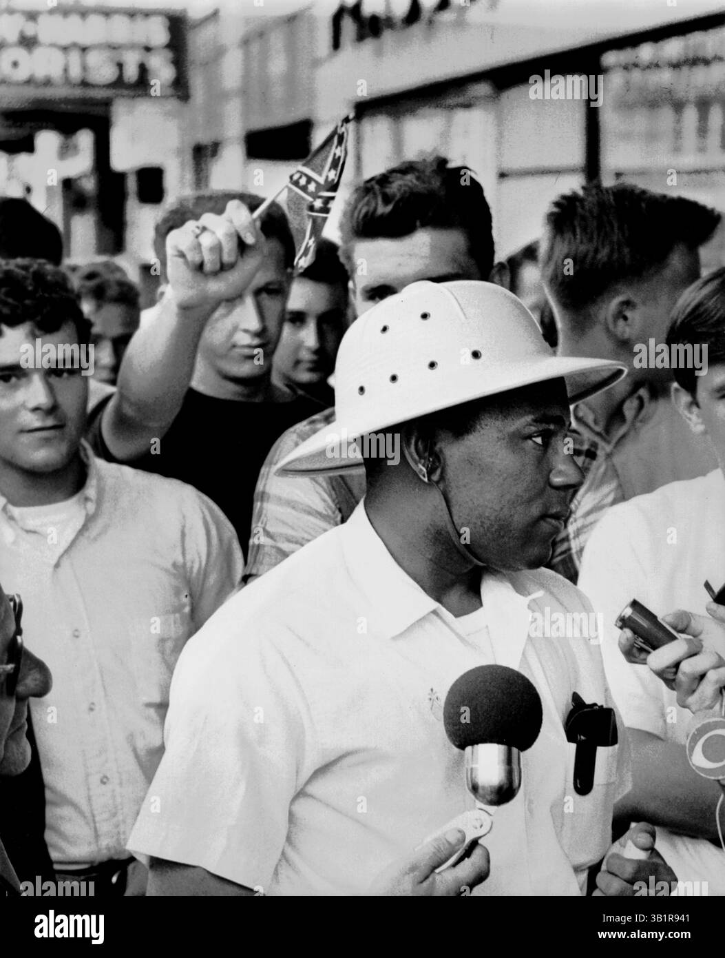 5 giugno 1966 - Memphis, Tennessee, Stati Uniti - James Meredith parla ai giornalisti del Peabody Hotel, a Memphis, Tenn. prima dell'inizio del suo 5 giugno 1966 come Butch Horn, 21, di Memphis, regge una bandiera confederata dietro di lui. Il giorno successivo, Meredith fu colpito sulla Highway 51 a circa due miglia a sud di Hernando, signorina. Mentre stava guidando la "marcia contro la paura" per incoraggiare i neri ad esercitare i loro diritti di voto. Meredith, che sfidò la segregazione per iscriversi all'Università del Mississippi nel 1962, completò la marcia da Memphis, Tenn., a Jackson, signorina, dopo essersi ripreso dalle sue ferite. (Credito immag Foto Stock