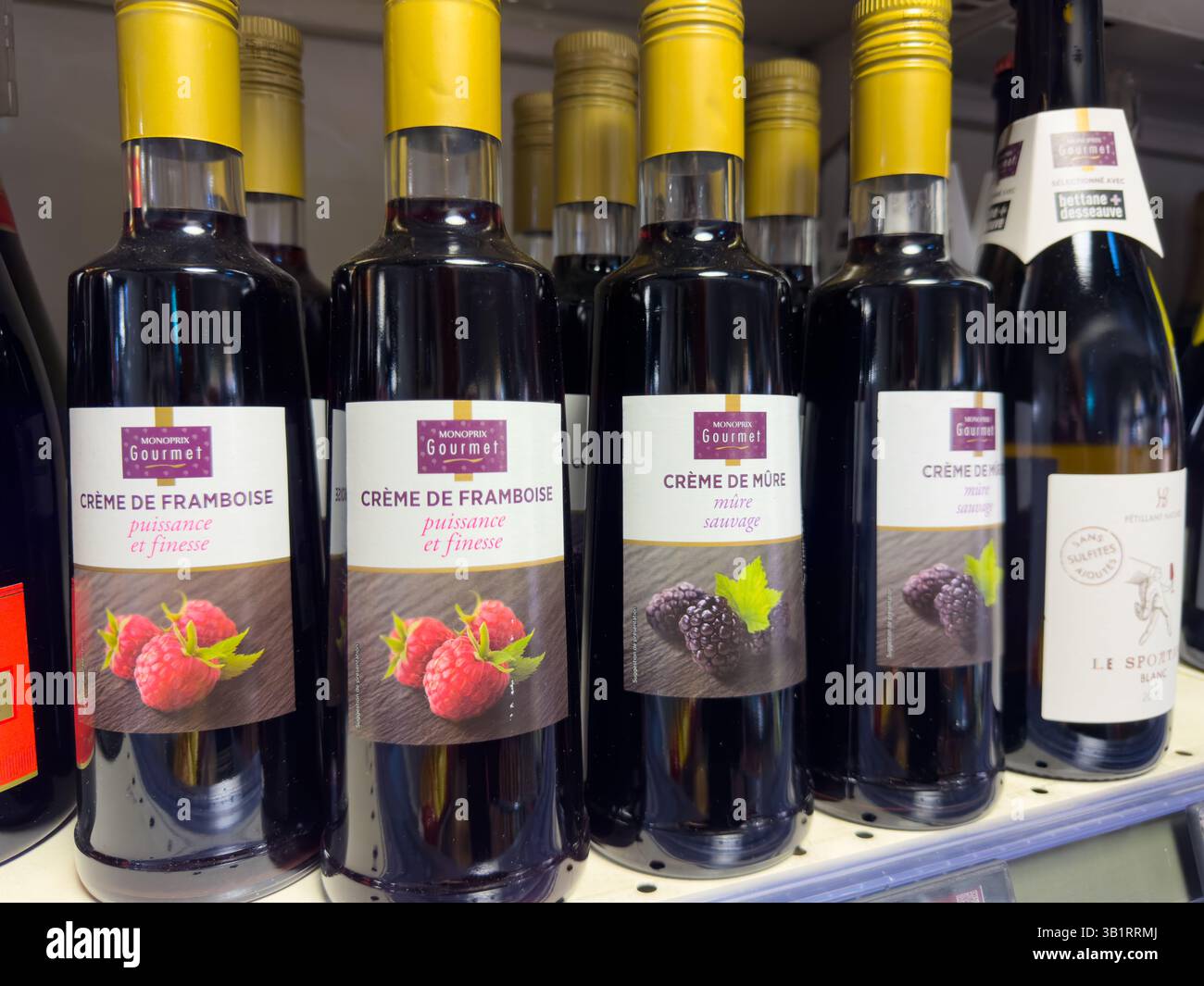 Bottiglie di lampone e sciroppo di blackberry esposte in un affascinante negozio gourmet nel cuore di un vivace mercato Foto Stock