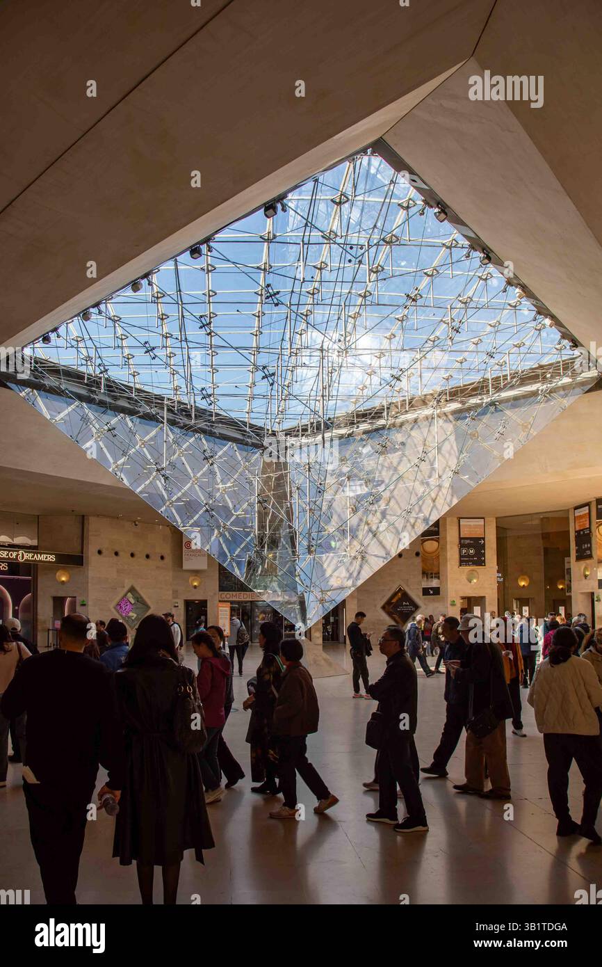 Persone in coda al Museo Nazionale d'Arte del Louvre nel centro commerciale Carrousel du Louvre con lucernario a piramide di vetro rovesciato a Parigi, Francia Foto Stock