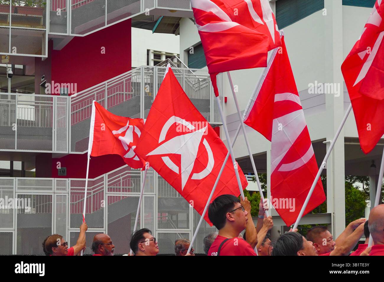 Singapore 2025 Apr23 - i sostenitori dell'SDP si sono rivestiti di bandiere rosse del partito alla Chongfu School il giorno delle nomine durante le elezioni generali di Singapore per Sembawa Foto Stock