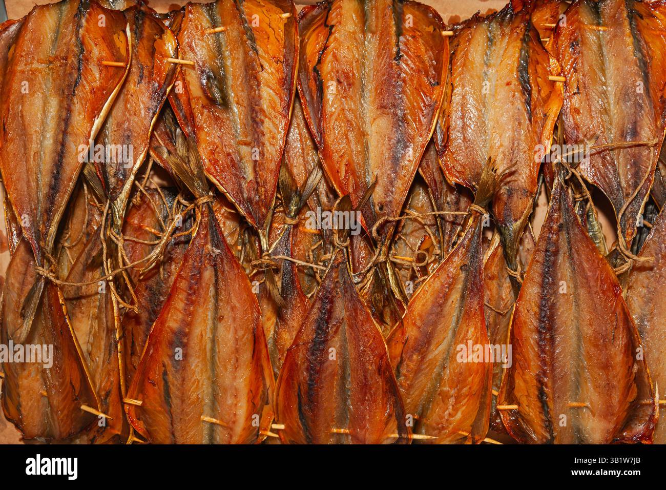 Primo piano di un lotto di pesce affumicato tagliato e finito. Foto Stock