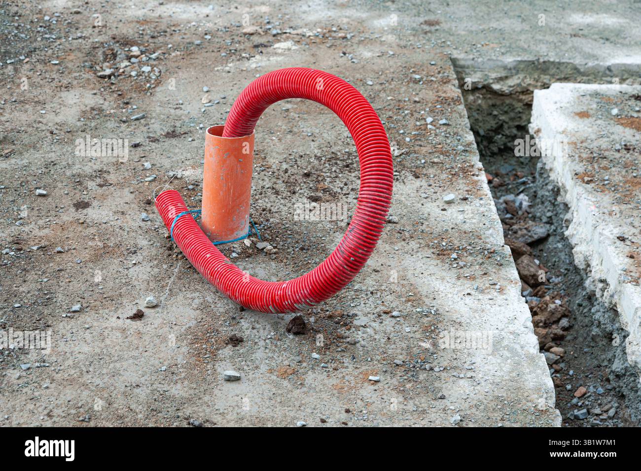 Posa delle comunicazioni a terra utilizzando tubi flessibili corrugati rossi. Foto Stock