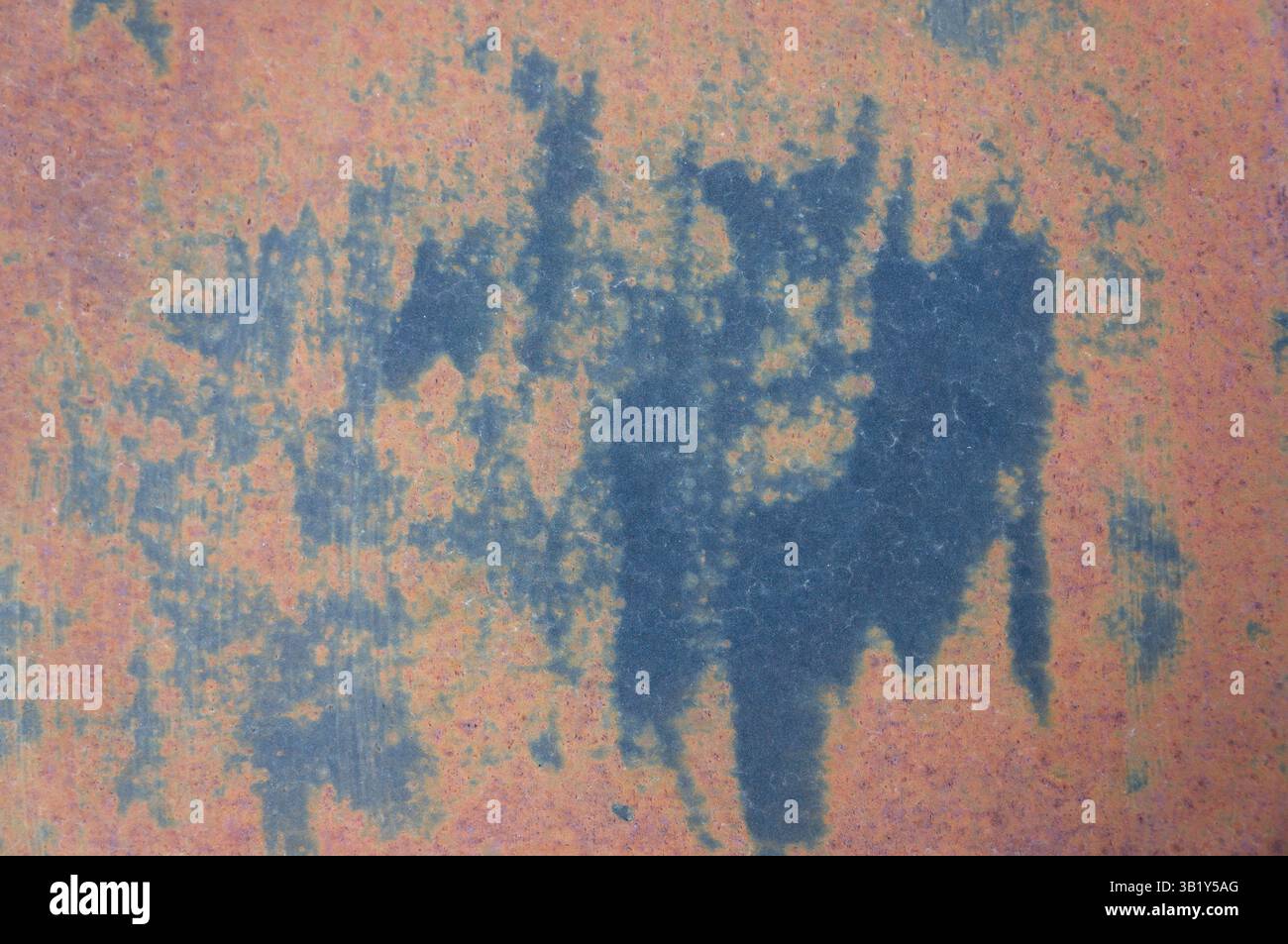 Lastra di ferro arrugginita con macchie blu che creano un'intrigante texture astratta che cattura l'essenza del decadimento e della bellezza intemprata Foto Stock