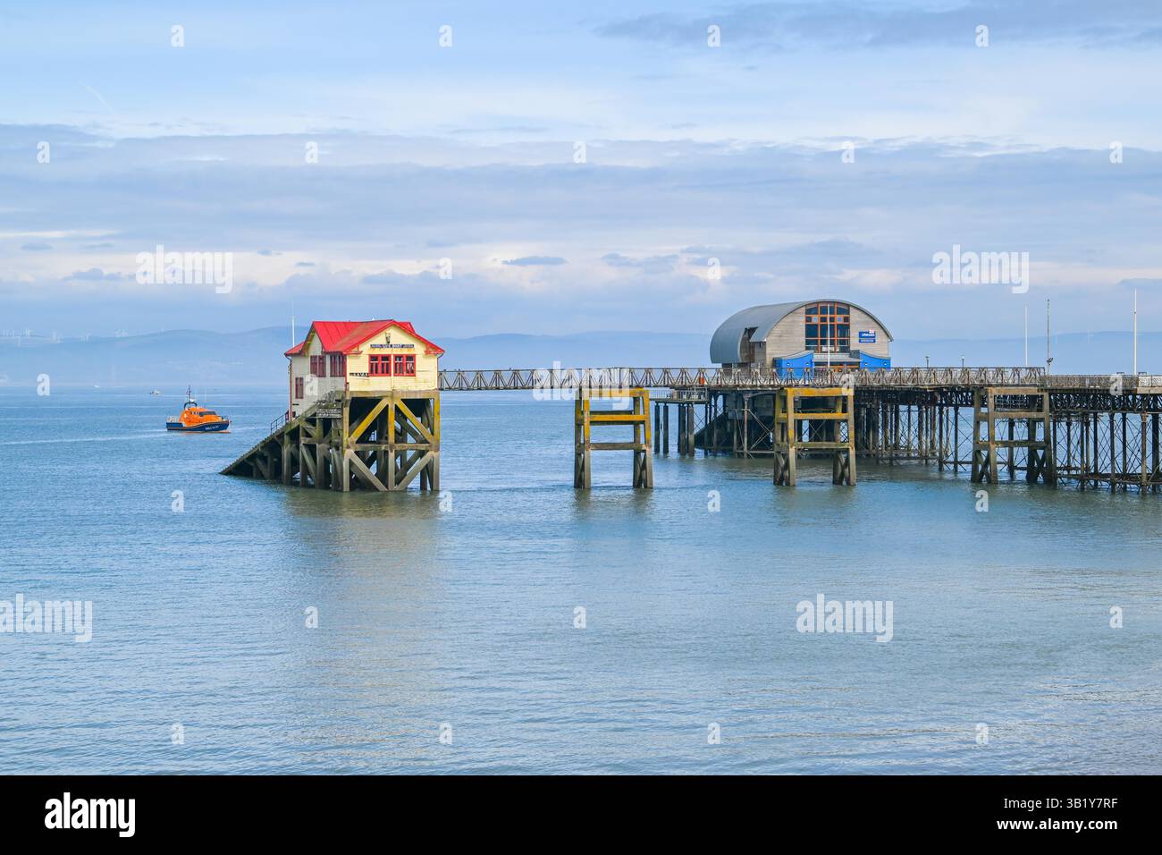 Mumbles, Galles, Regno Unito. 26 aprile 2025. Vista generale del Mumbles Pier a Mumbles vicino a Swansea, in Galles, che mostra le vecchie e nuove stazioni di salvataggio. I proprietari della Amusement Equipment Co's hanno dovuto chiudere una vasta sezione del molo vittoriano al pubblico nel 2023 a causa di problemi di sicurezza ed è in cattivo stato di riparazione e ha bisogno di milioni di sterline per ripristinarlo in condizioni di sicurezza. Anche la stazione di salvataggio RNLI sull'estremità del molo ha dovuto chiudere e trasferirsi a causa della mancanza di accesso sicuro e di problemi strutturali, con la scialuppa di salvataggio ora ormeggiata al di fuori della fine del molo. Crediti fotografici: Graham Hunt/Alamy Live Foto Stock