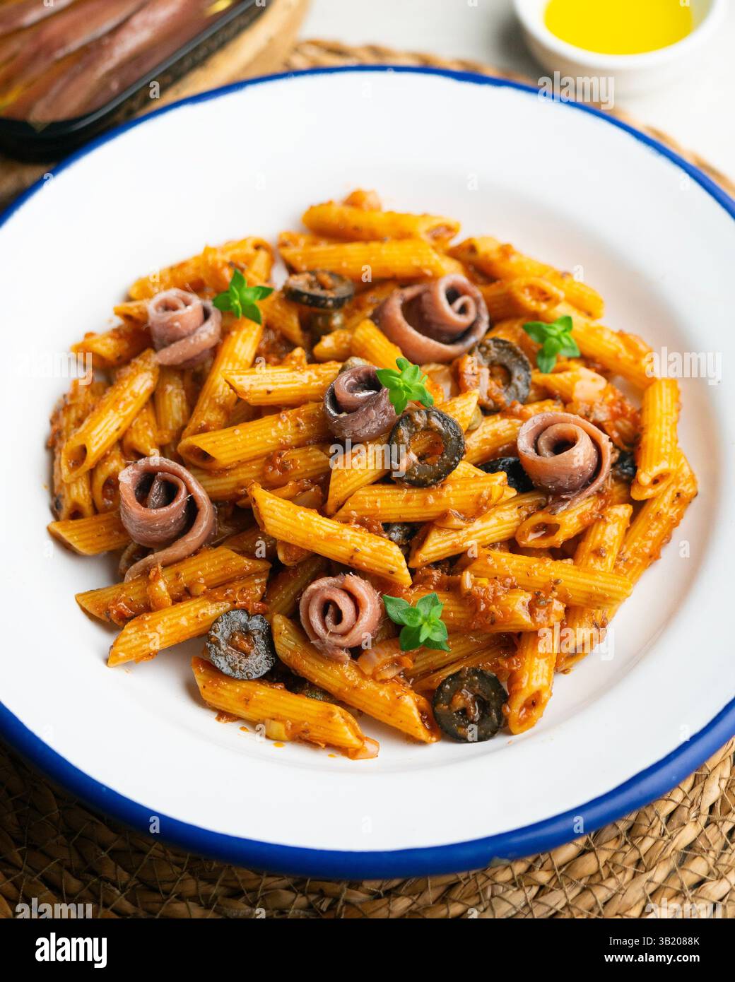 Pasta italiana maccheroni penne alla siciliana con acciughe e pomodoro Foto Stock