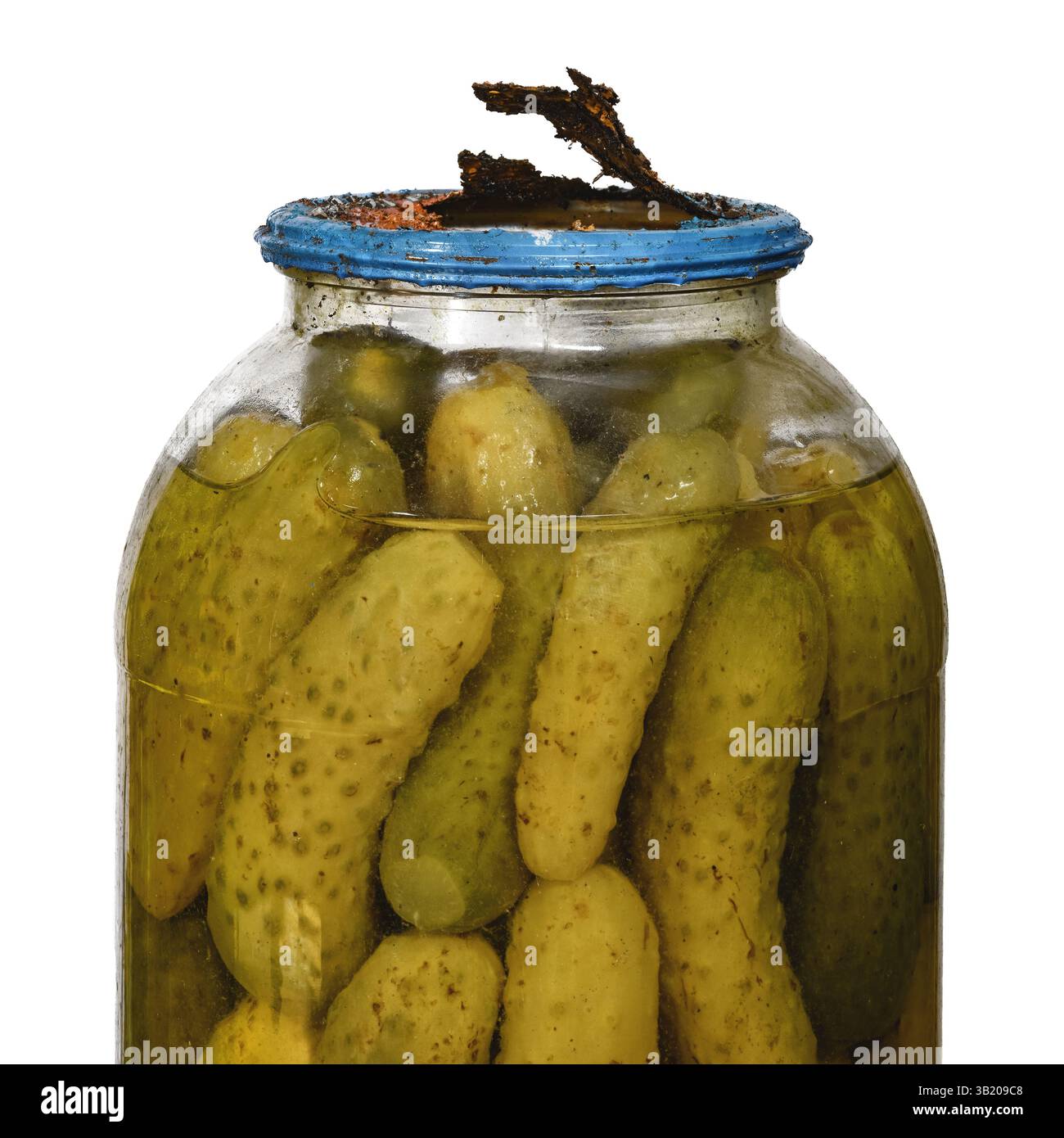 Sottaceti vecchi in un grande vaso di vetro con tappo del coperchio di latta rotto arrugginito in cattive condizioni isolato su sfondo bianco Foto Stock