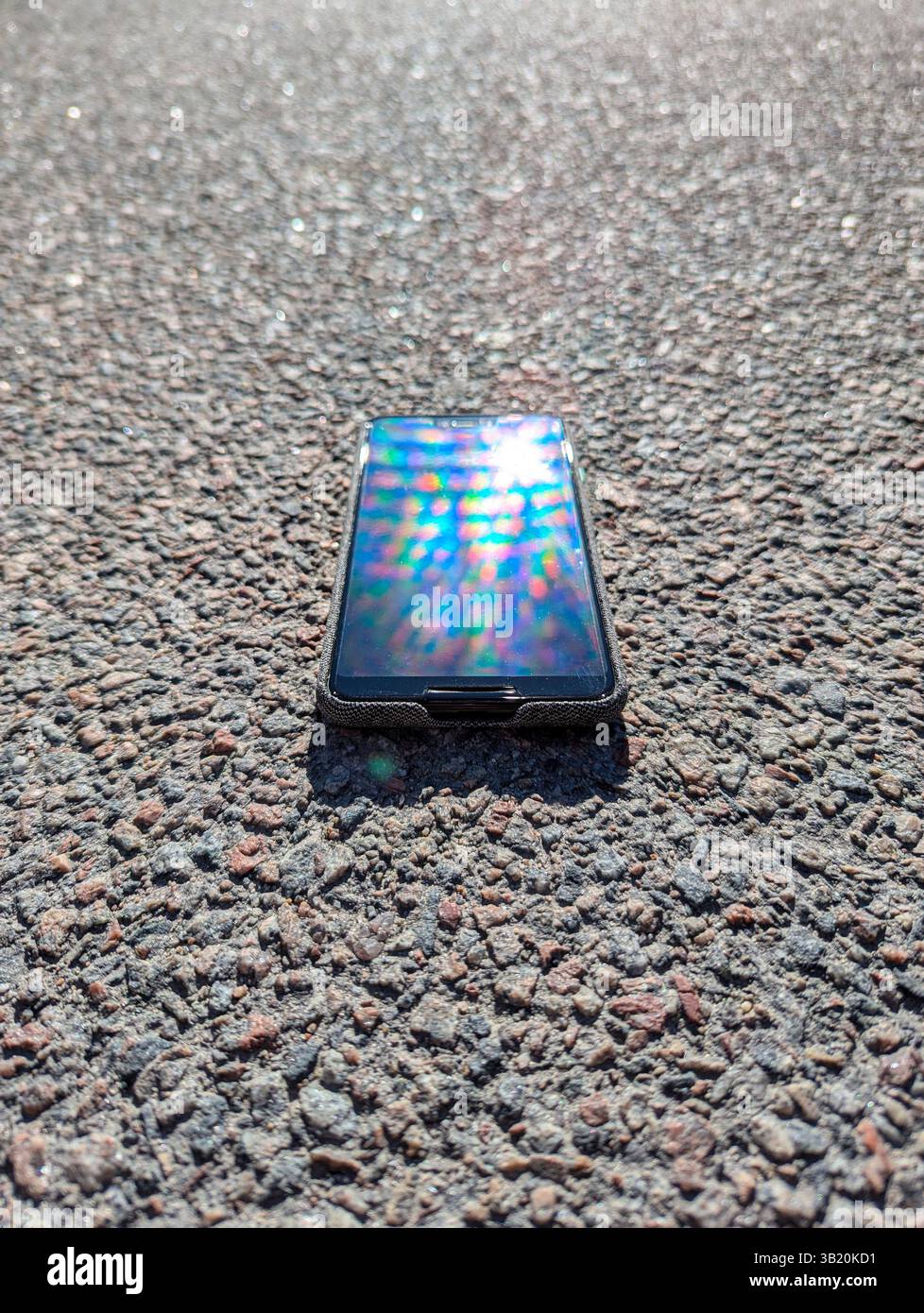 lo smartphone è appoggiato sull'asfalto Foto Stock