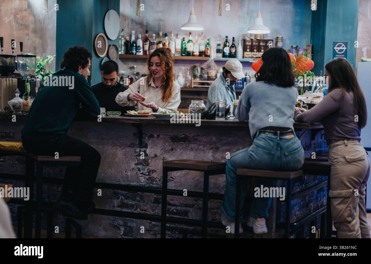 Il gruppo può gustare la preparazione del cibo presso il moderno lounge bar Foto Stock
