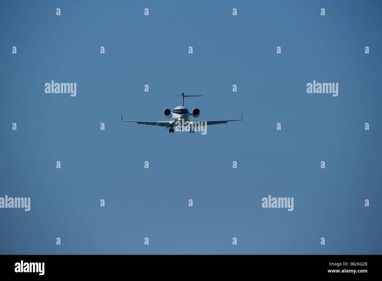 Aereo nel cielo blu. Business jet in preparazione per l'atterraggio Foto Stock