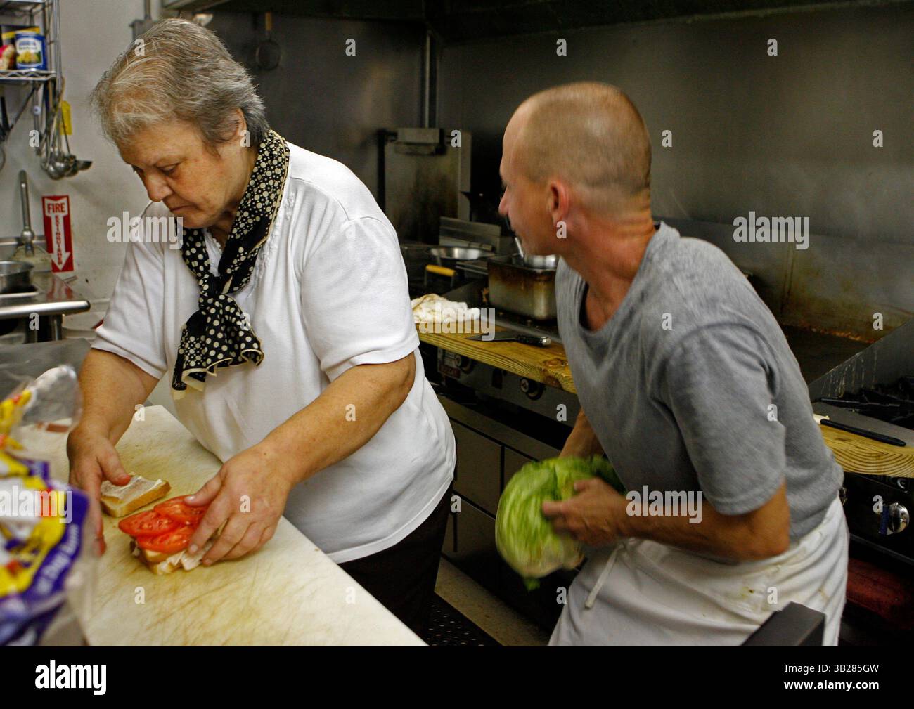 JIM DAMASKE | Times. NP 311025 DAMA ANGIE 1 (8/26/2009 CLEARWATER) Angie Chaconas assembla un sandwhich mentre il cuoco Mike Carlton lavora su un'insalata nell'Angie's Grill. Angie Chaconas, 74 anni, gestisce l'Angie's Restaurant nel centro di Clearwater dal 1971. È il tipo di posto in cui i clienti abituali si arrotolano ogni giorno e ordinano il panino di roast beef caldo .95 con purè di patate, mais e un panino. E' nota per aver dato da mangiare ai senzatetto ogni giorno del Ringraziamento. Ora ha appena aperto un secondo ristorante, chiamato Angie's Grill, in un centro commerciale su un tratto di Drew Street. Stesso menu, sam Foto Stock