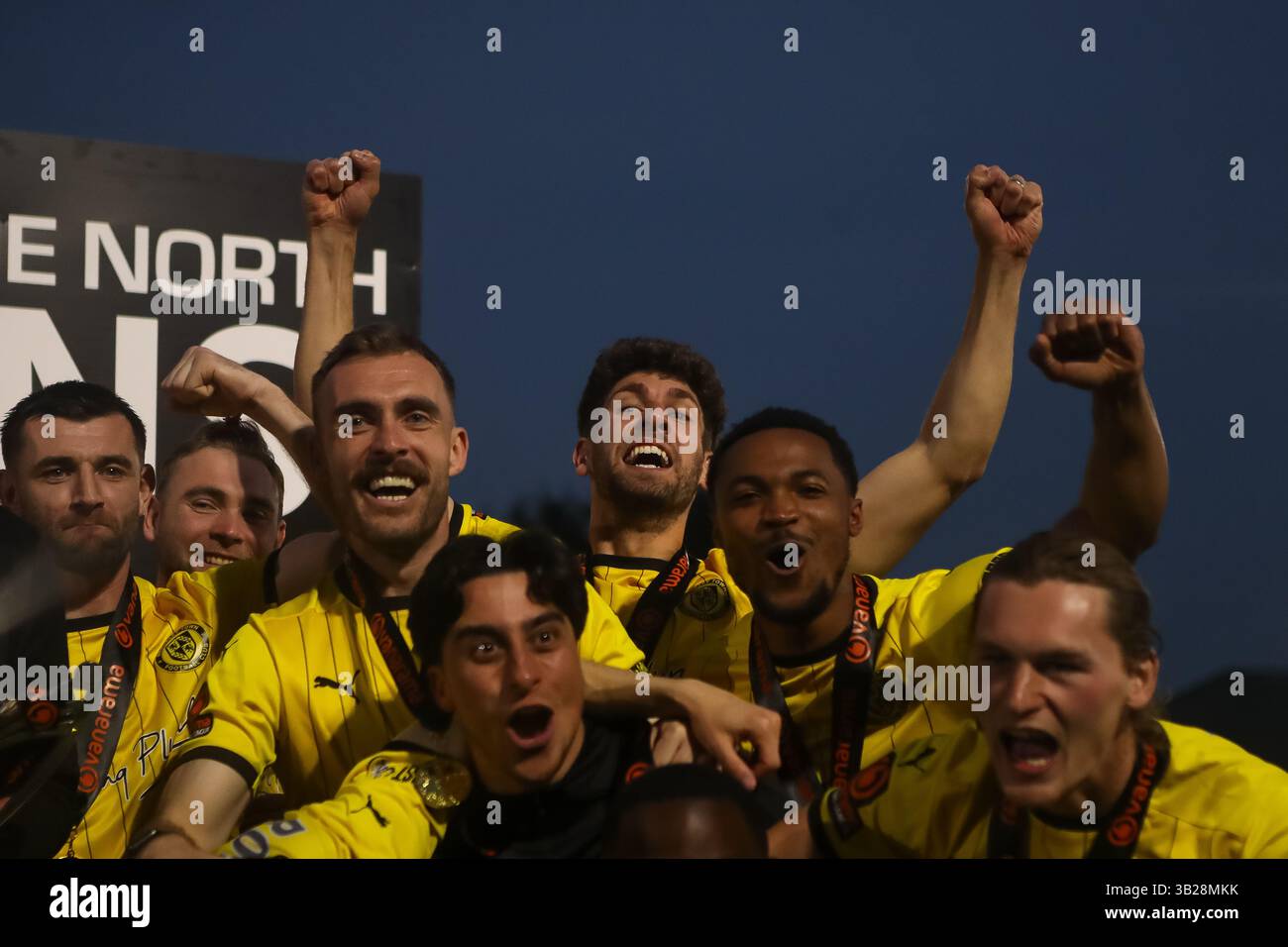 Un gruppo di giocatori Brackley festeggia con il trofeo insieme dopo la promozione nella Vanarama National League Foto Stock