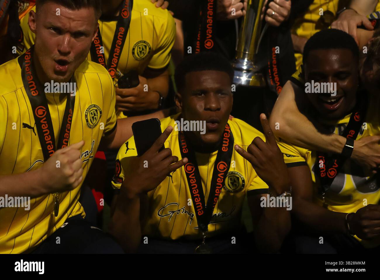 Un gruppo di giocatori Brackley festeggia con il trofeo insieme dopo la promozione nella Vanarama National League Foto Stock