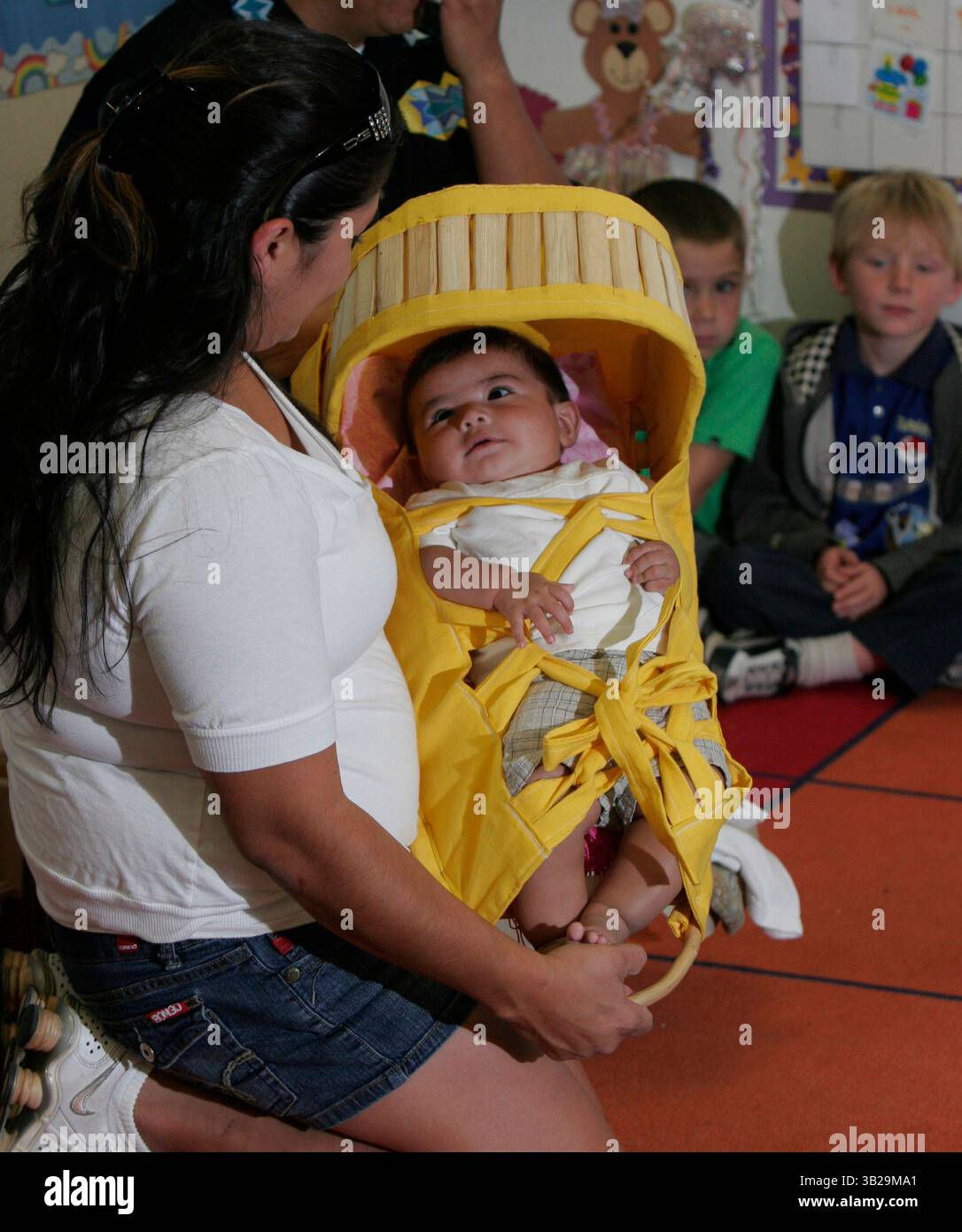 Alpine, CA 11/20/2009  Vanessa Christman, indiana di Kumeyaay, tiene il figlio di quattro mesi Ryder Christman su una tradizionale culla indiana, mentre le lezioni dell'asilo presso il Creekside Early Learning Center di Alpine hanno adottato un approccio vario per osservare il Ringraziamento nei loro programmi scolastici di quest'anno. (James Skovmand/Union-Tribune) foto obbligatoria Credit:JAMES SKOVMAND/Union-Tribune/ZUMA press (immagine di credito: © The San Diego Union-Tribune/ZUMApress.com) Foto Stock