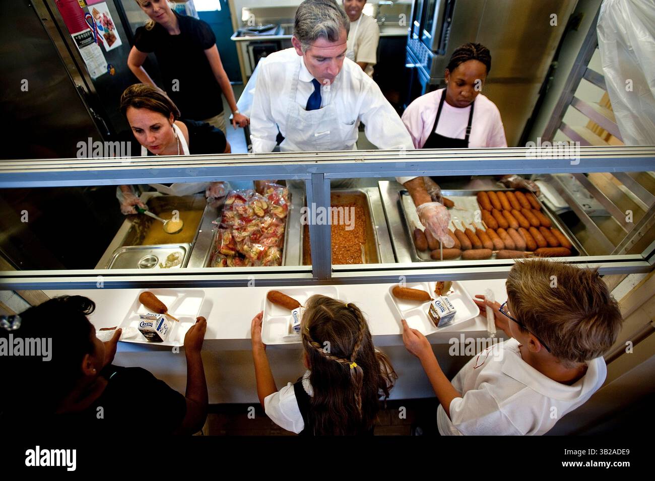 Il sovrintendente unificato di New Sacramento City Jonathan Raymond serve fagioli durante il pranzo alla Woodbine Elementary per celebrare il primo giorno dell'anno scolastico unificato di Sacramento City. Affiancandolo e servendo fette di mele e salsa di mele è membro del Consiglio scolastico Diana Rodriguez, a sinistra e servendo cani di mais è l'assistente dei servizi alimentari Danielle Hilliard.. 8 settembre 2009 (Credit Image: © Sacramento Bee/ZUMA Press) Foto Stock