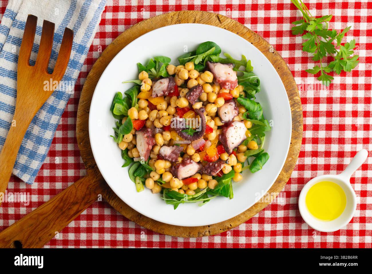 Salpicon de pulpo. Insalata di polpo con ceci, rucola e verdure. Tavolo con vista dall'alto e decorazioni natalizie. Foto Stock