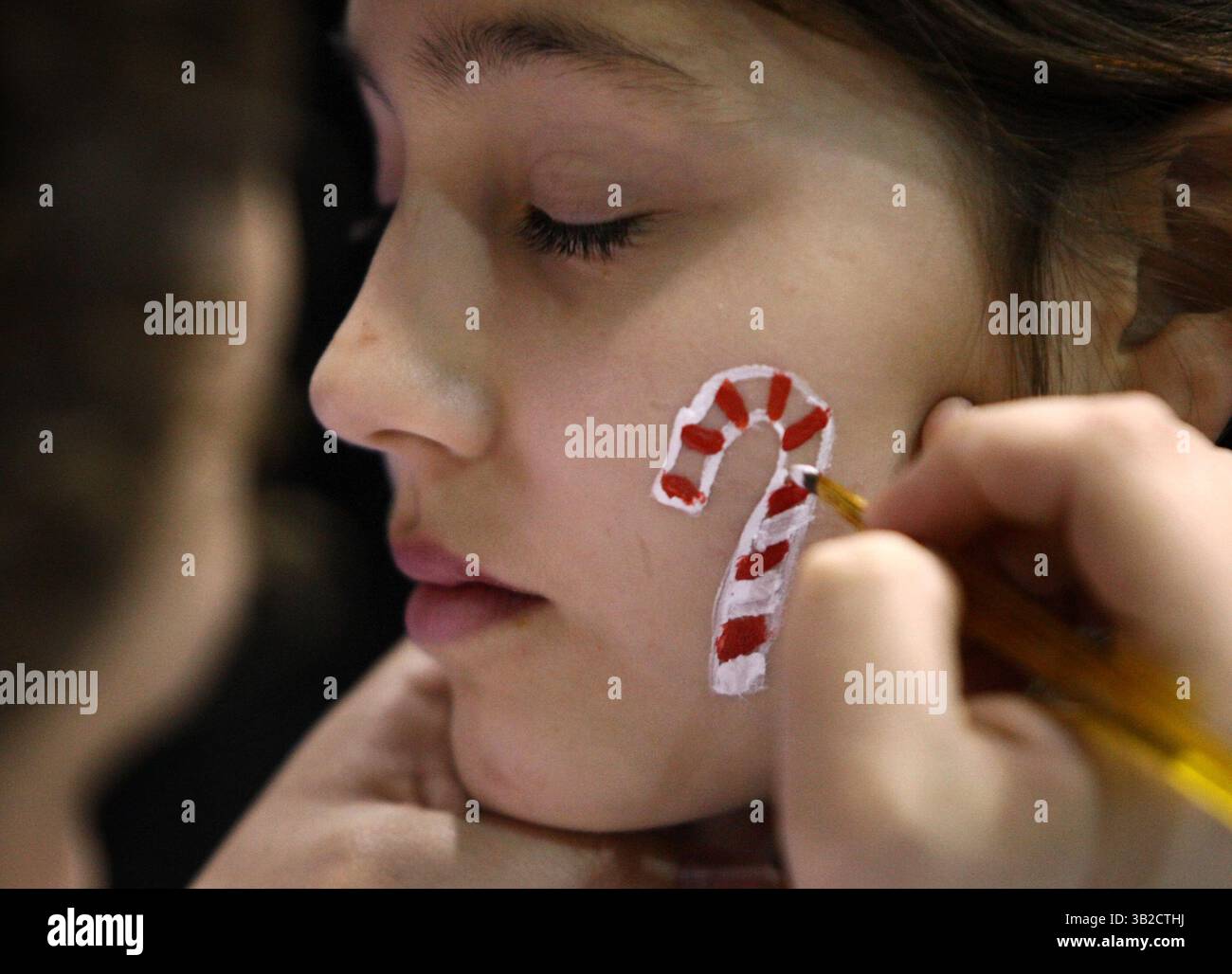 4 dicembre 2009 - FAIRBANKS, AK, Stati Uniti - John Wagner/News-Miner. Ana Raugh, 11 anni, chiude gli occhi mentre Alicia Ray crea con cura un bastone di caramelle con vernice per il viso durante il Fort Wainwright Holiday Pary and Tree Lighting del 2009 venerdì sera, 4 dicembre 2009, presso il centro fitness della base dell'esercito degli Stati Uniti. (Immagine di credito: © Fairbanks Daily News-Miner/ZUMApress.com) Foto Stock