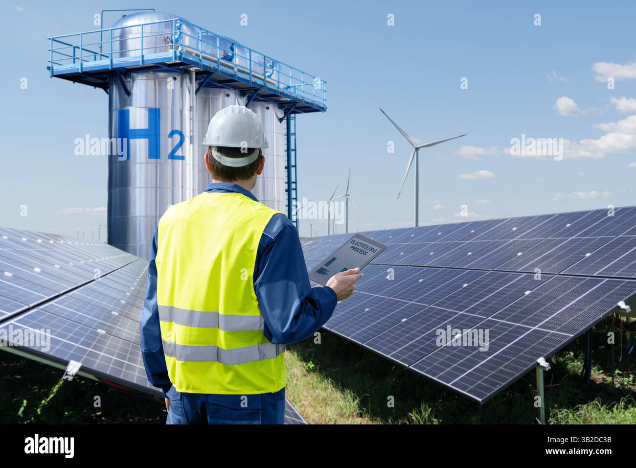 Ingegnere con computer tablet su uno sfondo di fabbrica di idrogeno. Foto Stock
