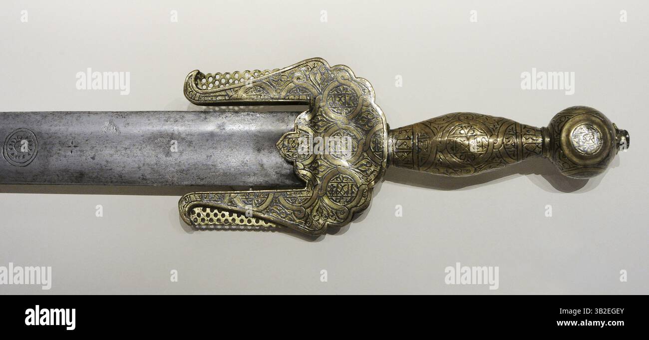 Spada Jineta. Tipo di spada nasride che fu introdotta in al-Andalus dagli Zenata, una delle tribù berbere che andò in aiuto del regime del Califfato nella loro lotta contro gli eserciti cristiani. xiv secolo. Acciaio, bronzo e argento. Particolare del manubrio con decorazione smaltata e niellata, sotto forma di bande circolari intrecciate, sovrapposte ad altre bande trasversali e longitudinali con scritte che alludono a Dio. Dalla Chiesa di San Marcelo (León, Spagna). Museo Archeologico Nazionale. Madrid. Spagna. Foto Stock