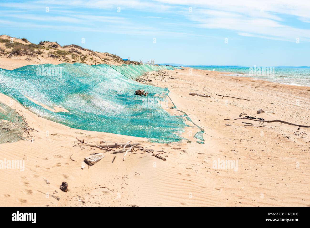 Fuoriuscita di olio combustibile. Duna di sabbia di barriera ricoperta da rete protettiva dall'olio combustibile gettato a terra dalle onde. Disastro ecologico, metodi di eliminazione. Foto Stock