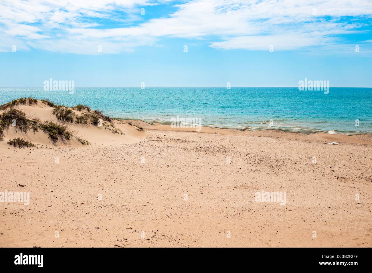 Duna di sabbia barriera con rete protettiva per la ritenzione dell'olio combustibile sulla costa del Mar Nero. Disastro ecologico, metodi di eliminazione. Foto Stock