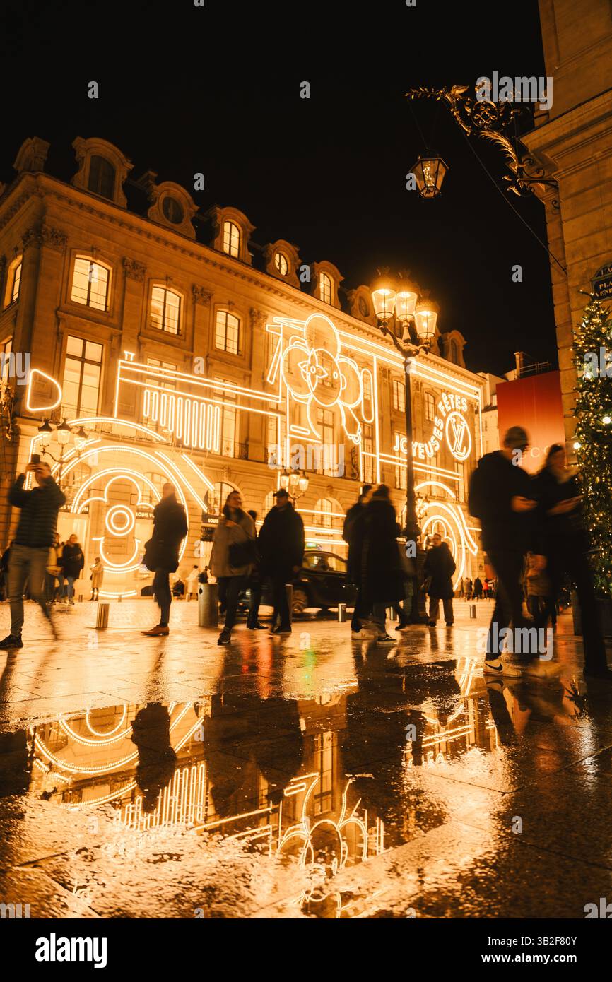 Splendore delle festività riflesse: Strada urbana con luci festive e riflessi bagnati sul pavimento Foto Stock
