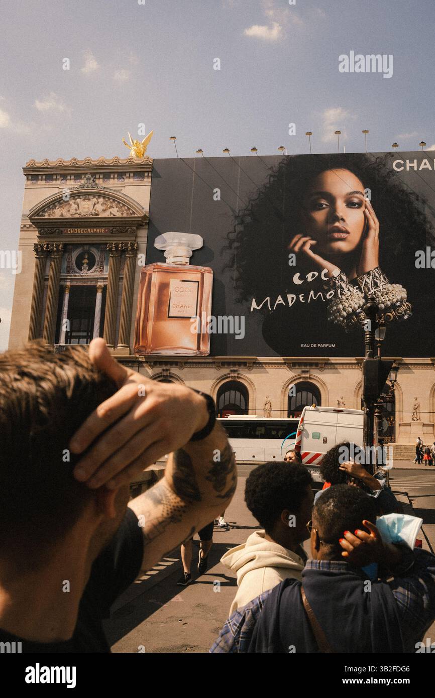 Urban Chic – folla vivace prima di un audace annuncio Chanel Foto Stock