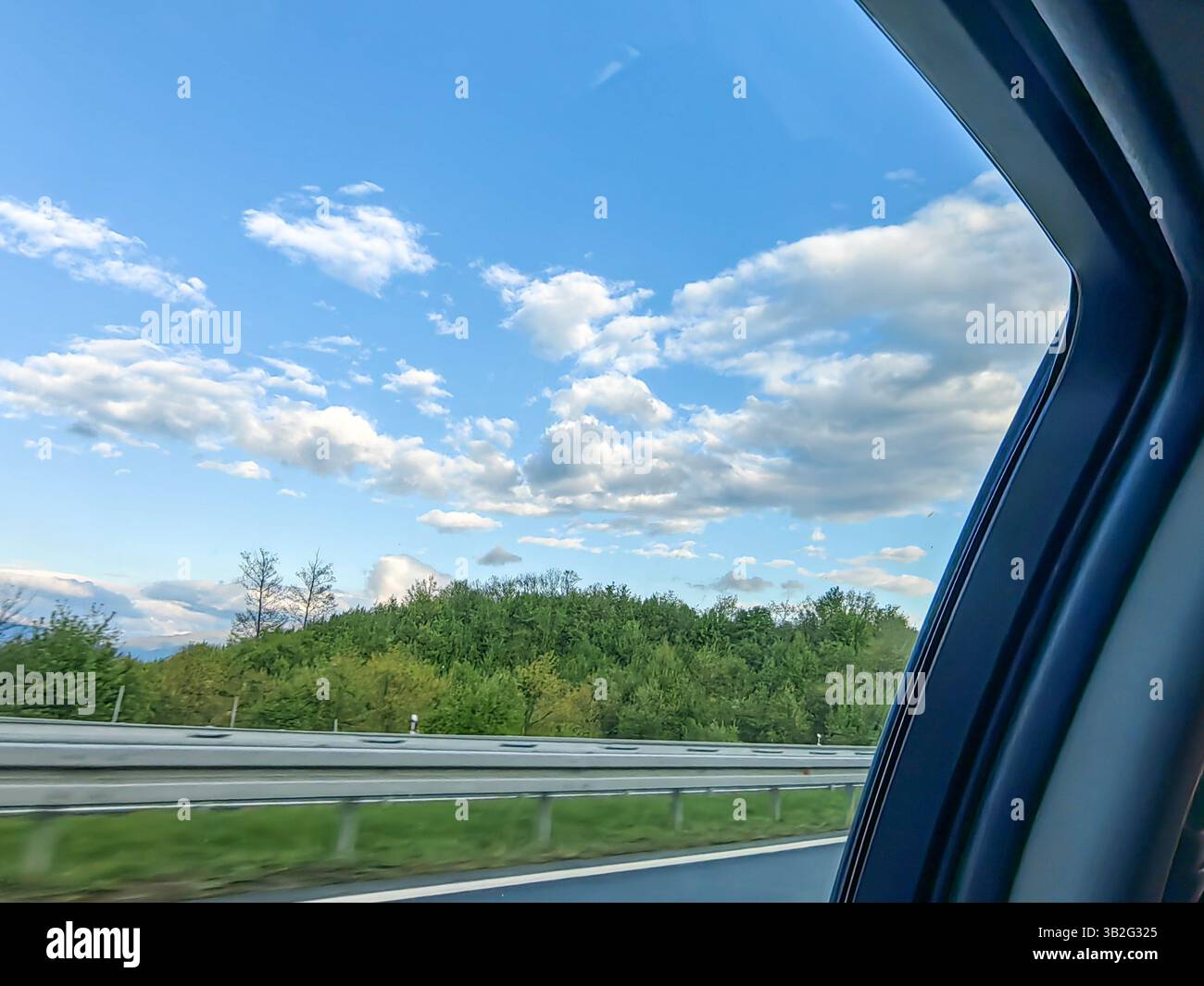 On the Road Again: Paesaggi ondulati sotto il cielo blu Foto Stock