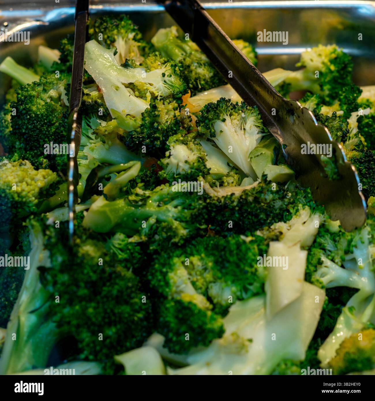Primo piano di broccoli appena cotti esposti in un contenitore di metallo argento in un tradizionale ristorante cinese a buffet. Il piatto è, colorato, e parte Foto Stock