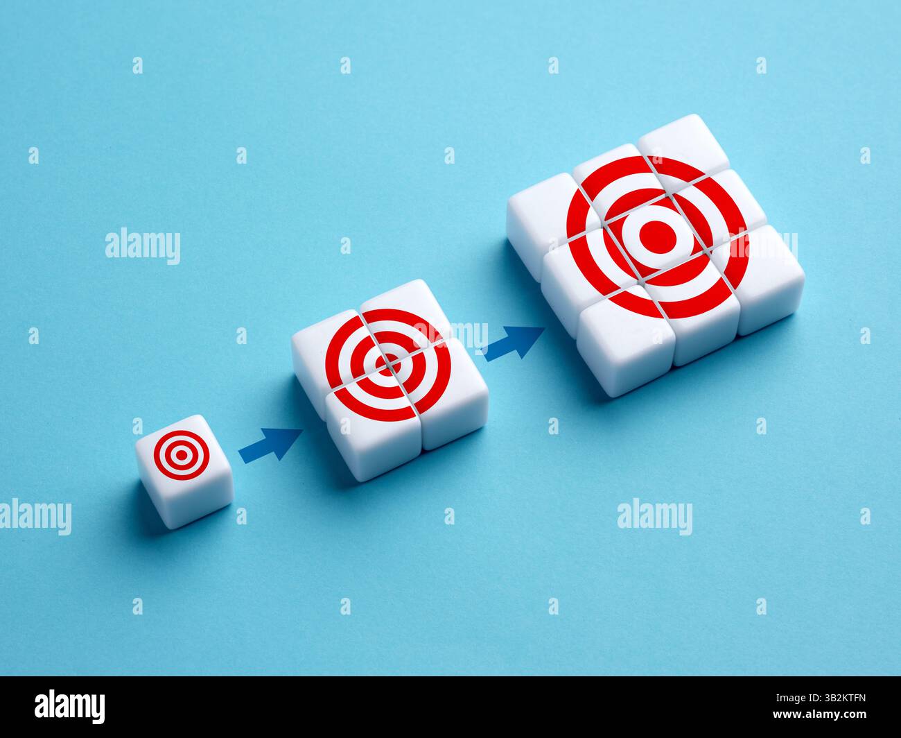 Sviluppo, miglioramento o avanzamento degli obiettivi. Perfezionamento o aggiornamento degli obiettivi aziendali. Simboli degli obiettivi sui cubi bianchi. Foto Stock