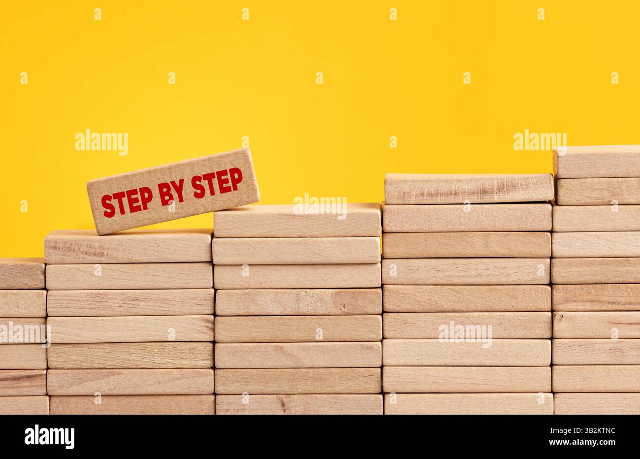 Formazione passo passo, successo aziendale e concetto di carriera. Blocco di legno con la parola passo dopo passo che sale la scala del blocco di legno Foto Stock