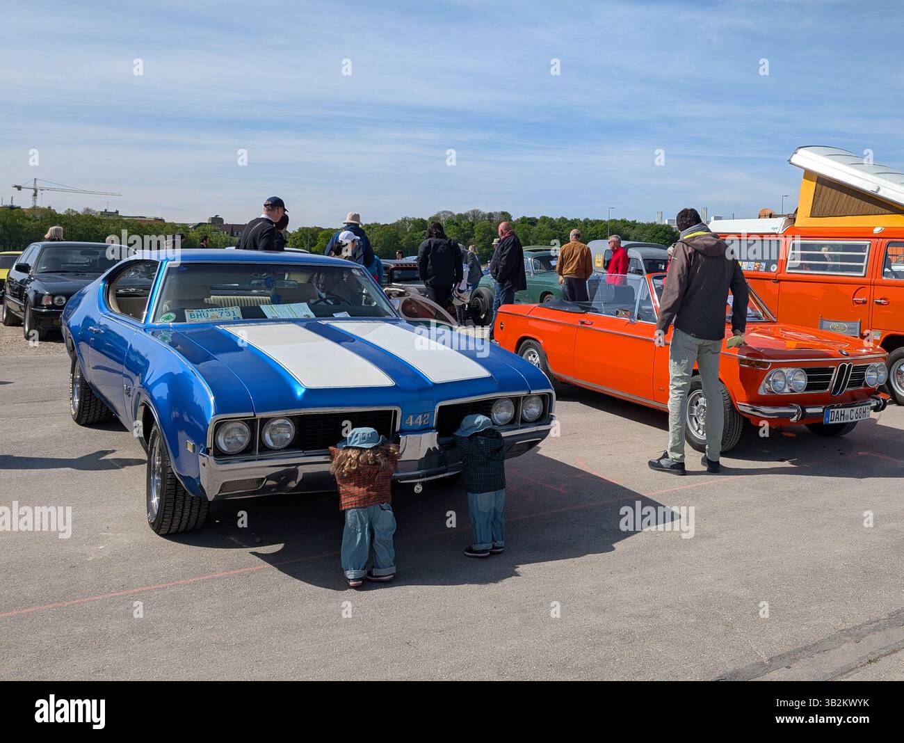 Monaco, Germania. 27 aprile 2025. Una Oldsmobile 442 blu e una BMW convertibile arancione sono esposte, tra gli altri veicoli d'epoca, durante l'incontro organizzato dall'Automobil Club Munchen (ACM) a Theresienwiese a Monaco di Baviera, Baviera, alta Baviera, Germania, il 27 aprile, 2025. due burattini sono collocati di fronte all'Oldsmobile per la decorazione e i visitatori possono vedere la vasta gamma di veicoli storici durante l'evento. (Foto di Michael Nguyen/NurPhoto)0 credito: NurPhoto SRL/Alamy Live News Foto Stock