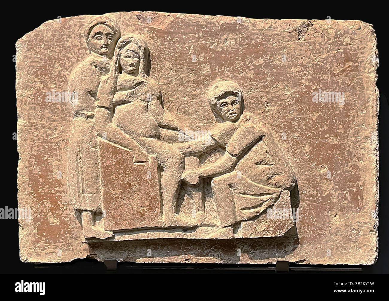 7670. Antica scultura romana di levatrice che assiste ad una donna che partorisce. Foto Stock