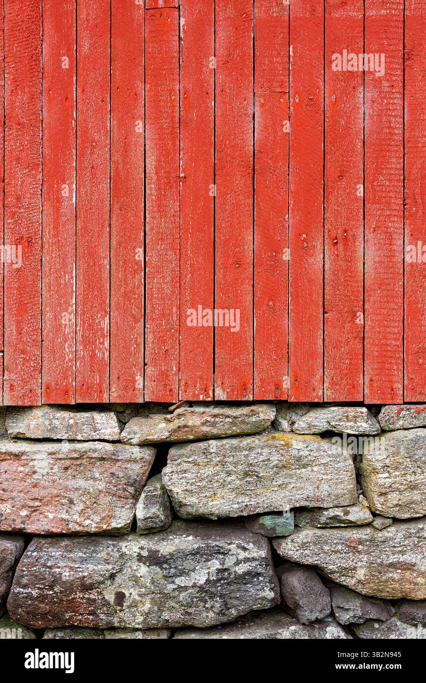 Le vivaci tavole di legno rosso si innalzano sopra un solido fondamento in pietra, mettendo in risalto materiali contrastanti e un'estetica rustica. Foto Stock