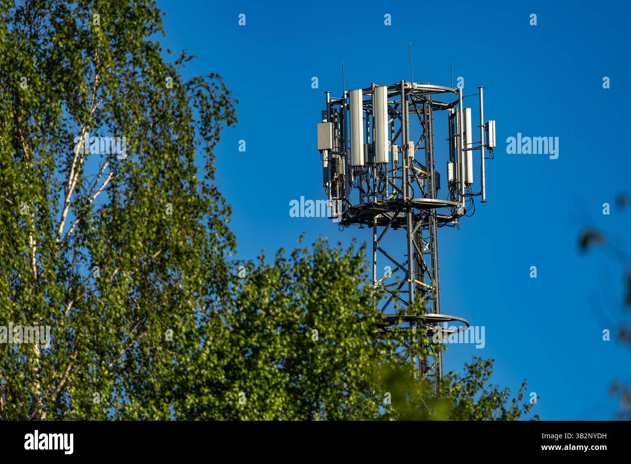 Antenna del telefono cellulare su sfondo blu, trasmettitore e ricevitore di segnale 5g, televisione e radio Foto Stock