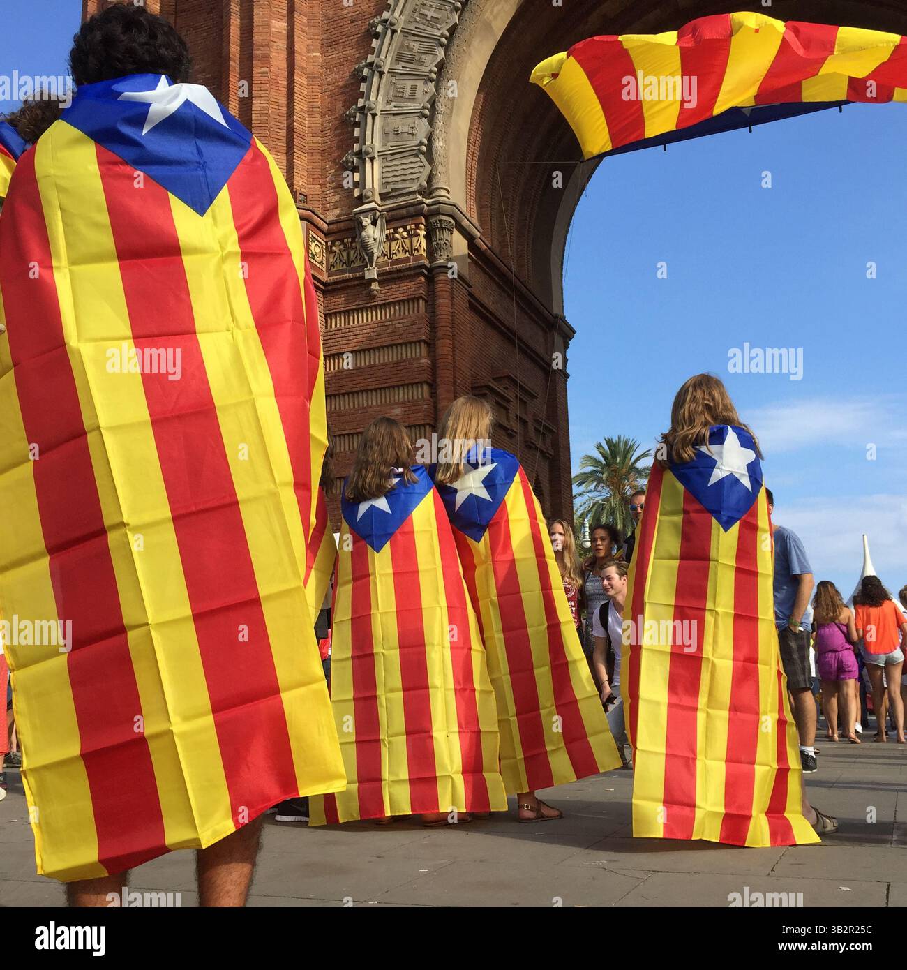 11 settembre 2015 - Barcellona, Spagna - le persone posano di fronte a una gigantesca bandiera catalana all'Arco di Trionfo di Barcellona. Barcellona era un mare di rosso e giallo mentre folle che portavano bandiere separatiste marciavano in città per celebrare la giornata nazionale catalana. Gli organizzatori speravano di attirare almeno 500.000 persone per una manifestazione pro-indipendenza usando lo slogan ''cominciamo a costruire un nuovo paese. (Immagine di credito: © Ruaridh Stewart via ZUMA Wire) Foto Stock