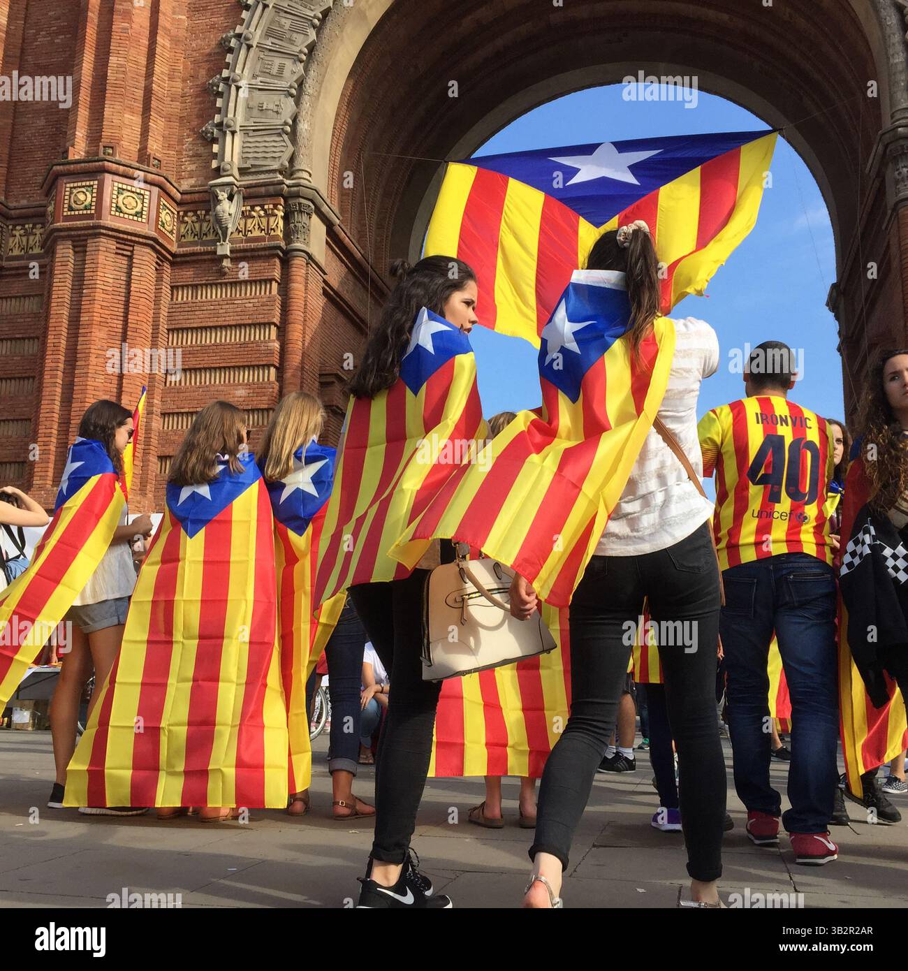 11 settembre 2015 - Barcellona, Spagna - le persone posano di fronte a una gigantesca bandiera catalana all'Arco di Trionfo di Barcellona. Barcellona era un mare di rosso e giallo mentre folle che portavano bandiere separatiste marciavano in città per celebrare la giornata nazionale catalana. Gli organizzatori speravano di attirare almeno 500.000 persone per una manifestazione pro-indipendenza usando lo slogan ''cominciamo a costruire un nuovo paese. (Immagine di credito: © Ruaridh Stewart via ZUMA Wire) Foto Stock