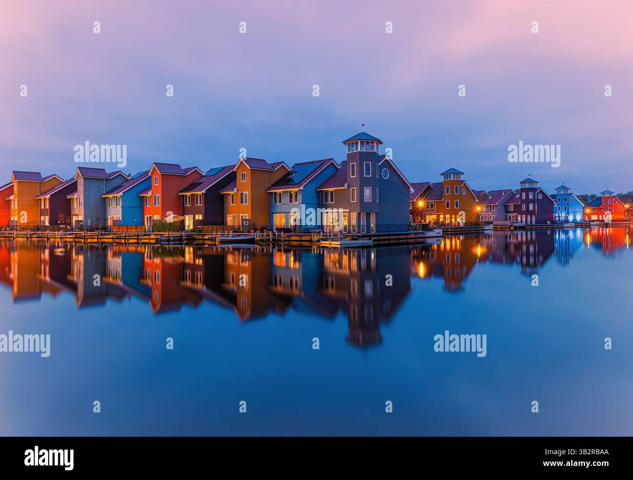 Una serata al crepuscolo presso le iconiche case colorate del Reitdiephaven, un'area residenziale nella città di Groningen, Paesi Bassi. Foto Stock