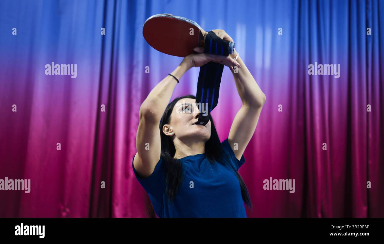 Donna caucasica con disabilità prepararsi per un gioco di ping pong come parte di uno stile di vita sano e attivo Foto Stock