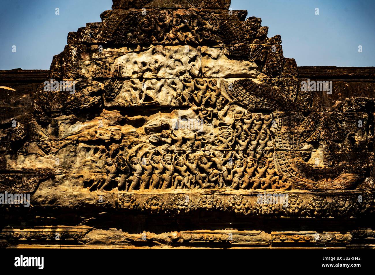 Intricate incisioni in pietra che raffigurano scene storiche o mitologiche sulla facciata di un tempio, mostrando figure dettagliate e disegni decorati. Foto Stock