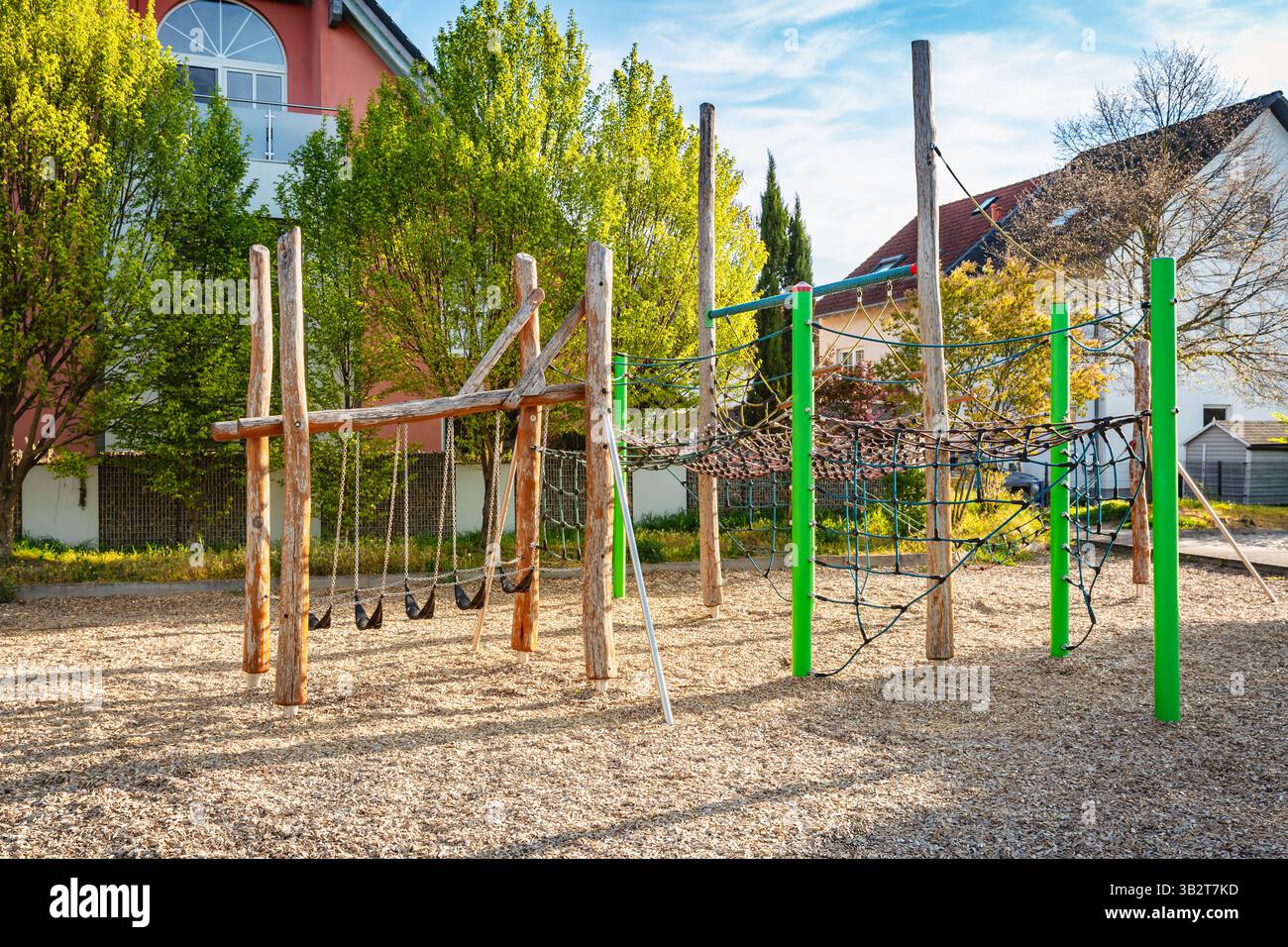 Parco giochi pubblico vuoto nelle giornate di sole con attrezzature da gioco in legno Foto Stock