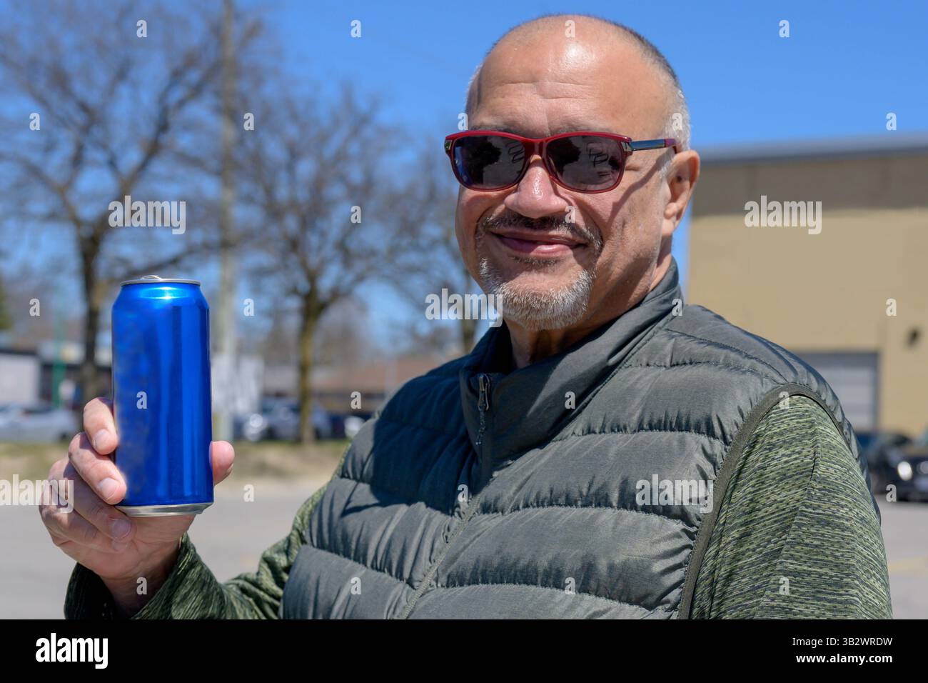 Uomo adulto che tiene una lattina da bere in città Foto Stock