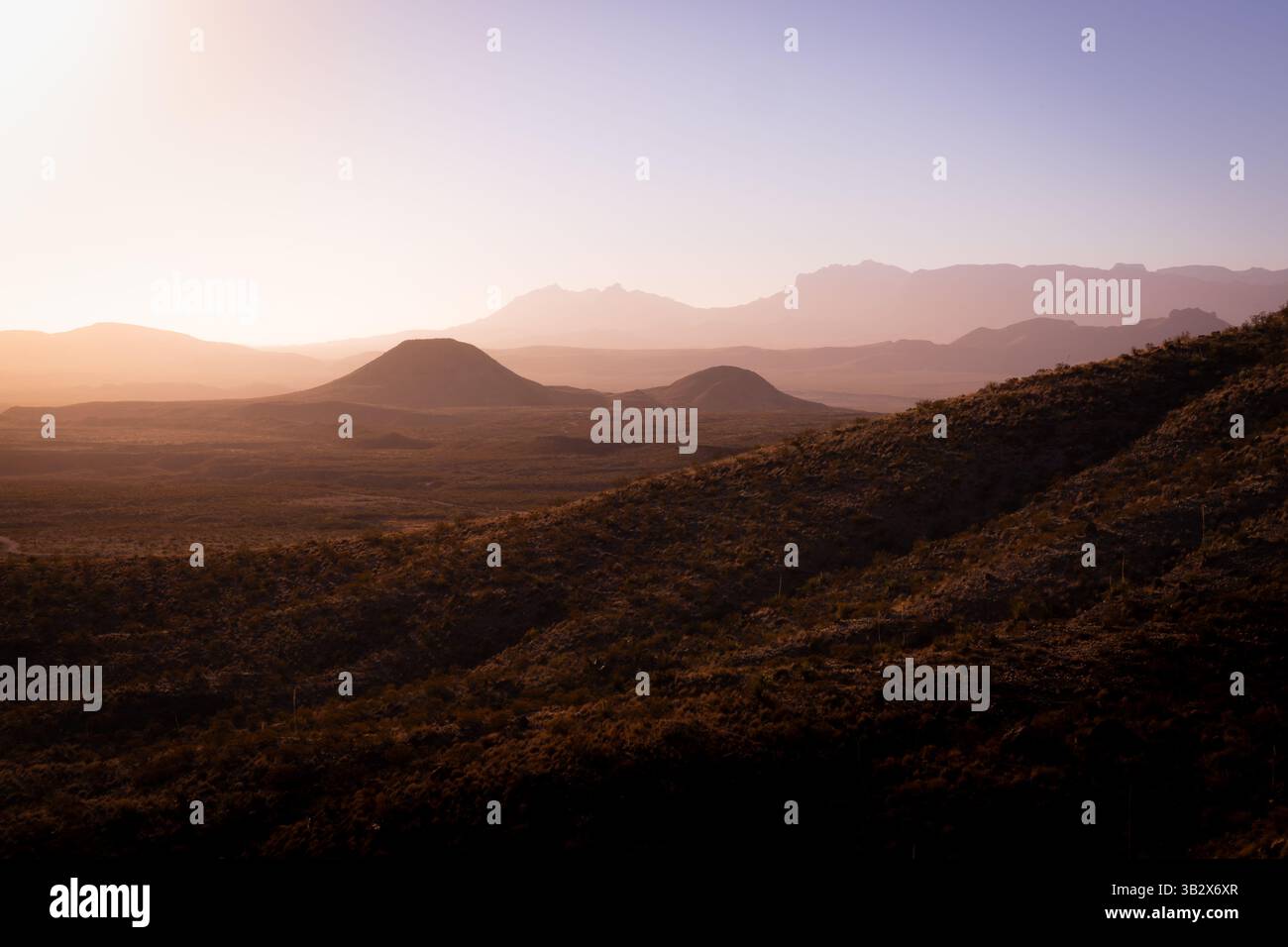 La foschia soleggiata del mattino presto splende sulle lontane montagne del deserto lungo il confine tra Texas e Messico. Foto Stock