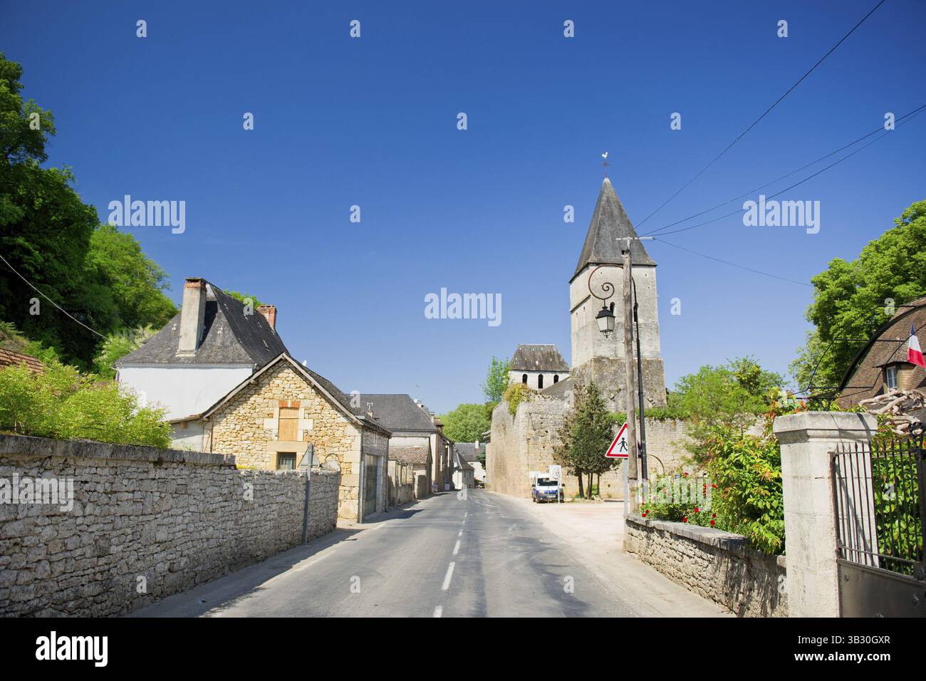 Tipico villaggio francese nella Dordogna con strada e chiesa Foto Stock